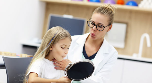 terapeuta del habla ayudando a una niña