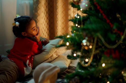 Girl sitting under the Christmas tree