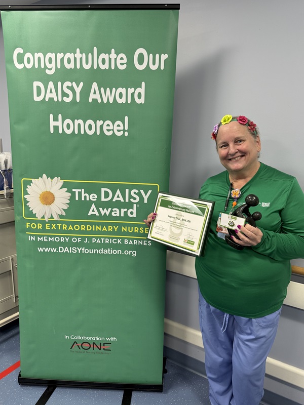 awardee wearing a headband of daisies, daisy award statue, and certificate.