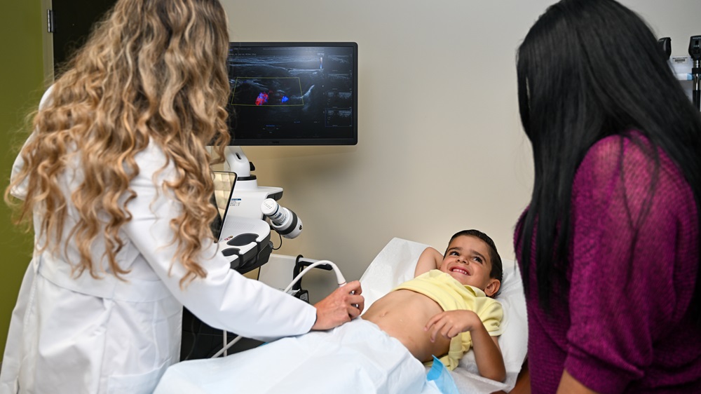 Dr. Felipez performing intestinal ultrasound on young boy patient