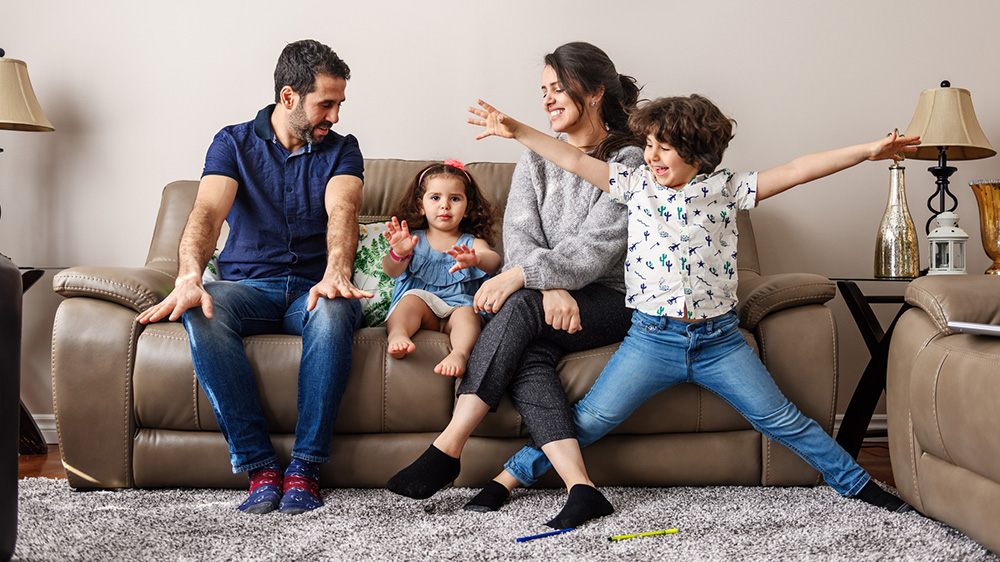 A family of four having fun in their living room.