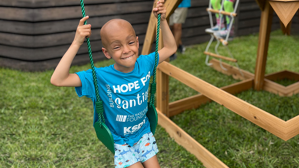 patient santiago happily swinging at a park.