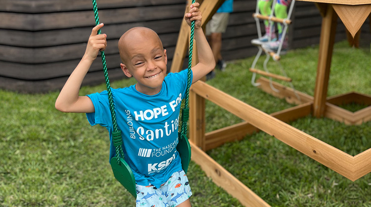 patient santiago happily swinging at a park.