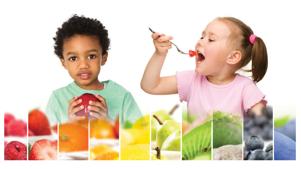 boy holding apple and girl eating with a fork, rainbow of fruits and vegetables.