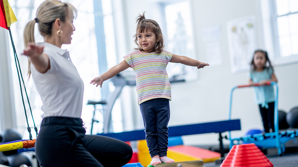 little girl during rehab exercises with therapist