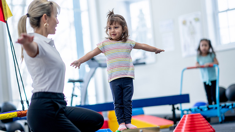 little girl during rehab exercises with therapist