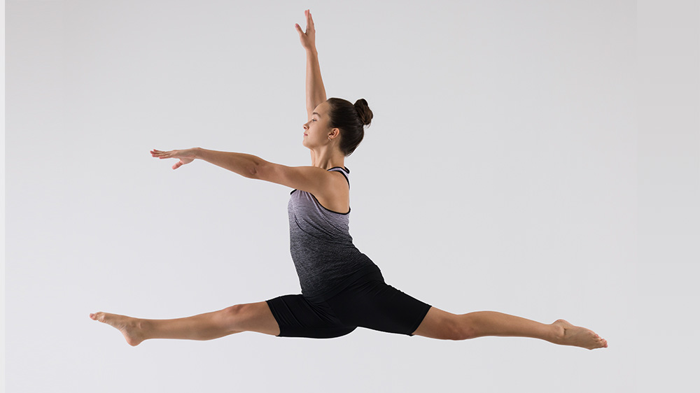 young dancer mid leap in the air.