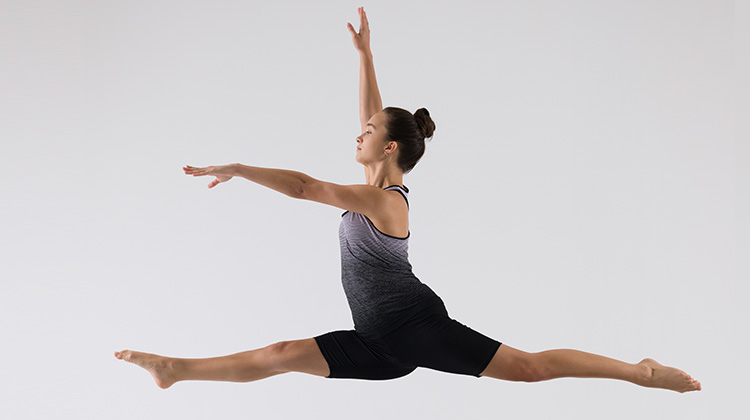 young dancer mid leap in the air.