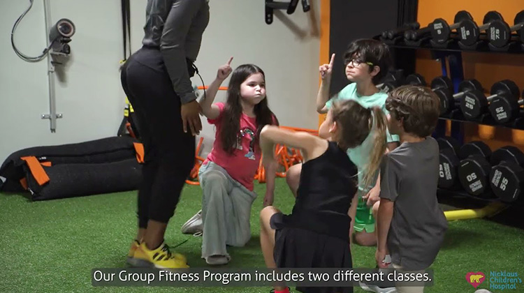 group of kids exercising during class with trainer.