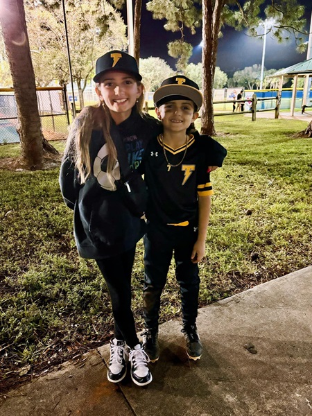 Rydon in baseball uniform with his sister.