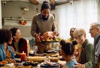 Multicultural family sitting down for a holiday meal